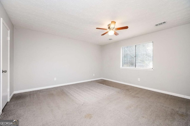 carpeted empty room with ceiling fan and a textured ceiling