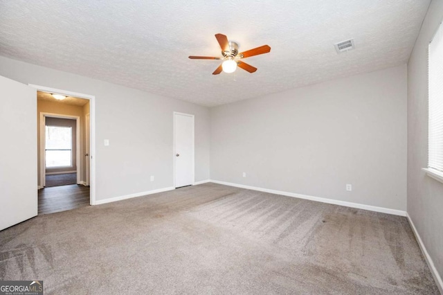 spare room featuring ceiling fan, a textured ceiling, and carpet flooring