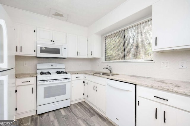 kitchen with sink, white appliances, and white cabinetry