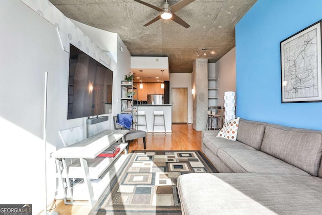 living room with ceiling fan and light hardwood / wood-style flooring