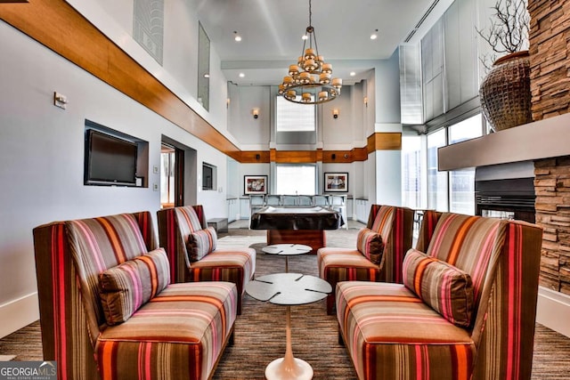 living room with pool table, a towering ceiling, and a notable chandelier