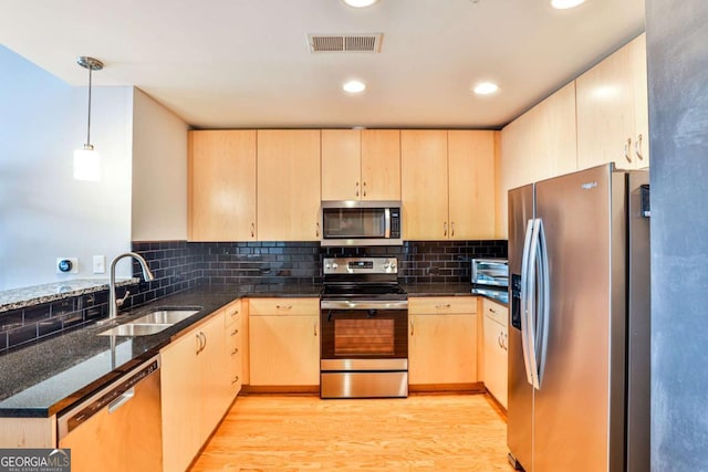 kitchen featuring stainless steel appliances and light brown cabinetry