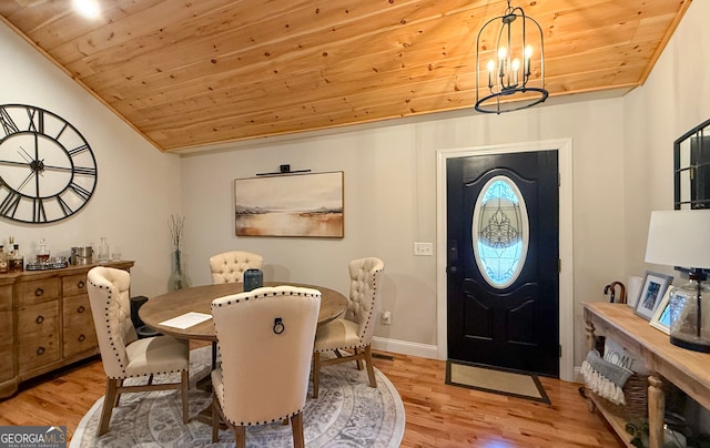 dining room featuring light wood-type flooring, a chandelier, and wood ceiling