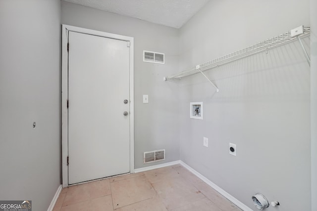 laundry area featuring hookup for an electric dryer, hookup for a washing machine, and a textured ceiling