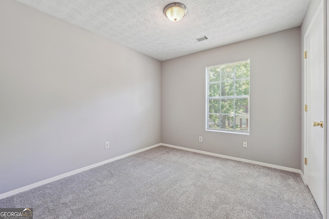 carpeted spare room featuring a textured ceiling