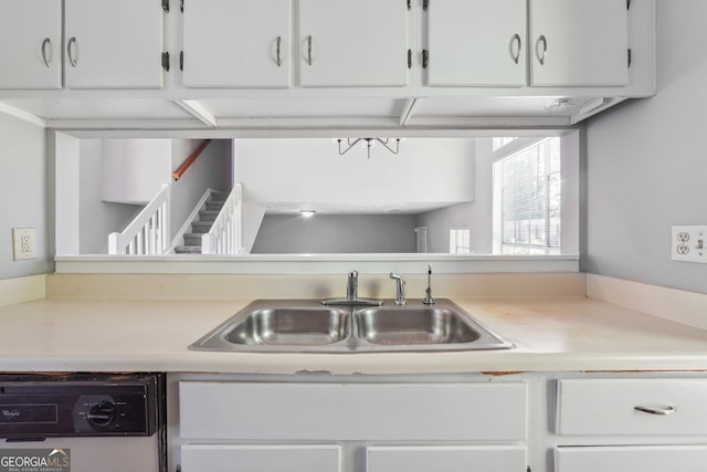 kitchen featuring white cabinetry, white dishwasher, and sink