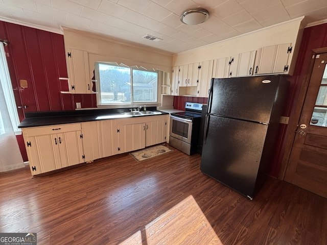 kitchen featuring stainless steel range with electric cooktop, black fridge, dark hardwood / wood-style flooring, crown molding, and sink