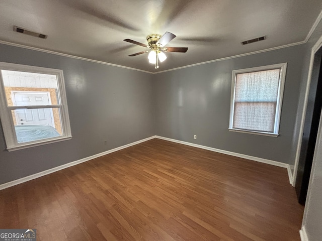 unfurnished room featuring ceiling fan, plenty of natural light, ornamental molding, and dark hardwood / wood-style floors