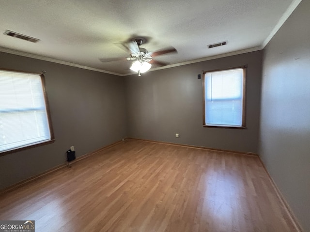 spare room featuring ceiling fan, a textured ceiling, ornamental molding, and light hardwood / wood-style floors