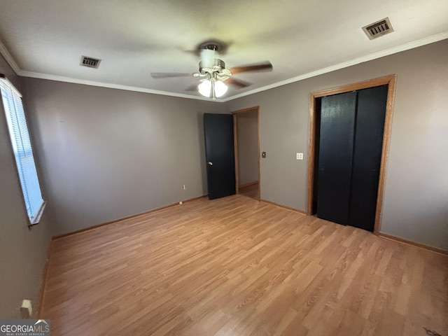 unfurnished bedroom with ceiling fan, ornamental molding, a closet, and light hardwood / wood-style flooring