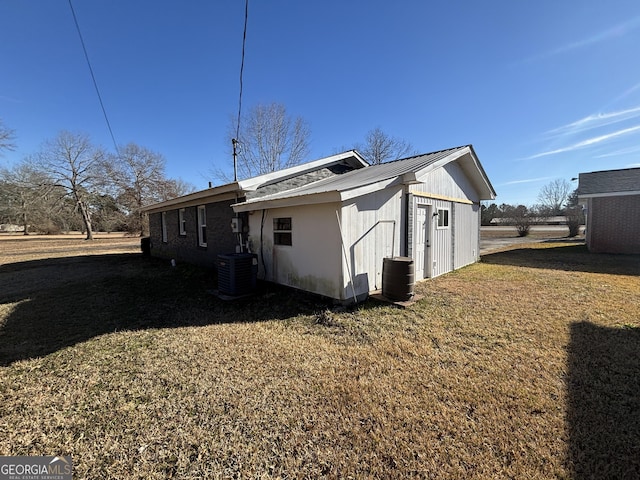 view of side of property featuring a lawn and central air condition unit