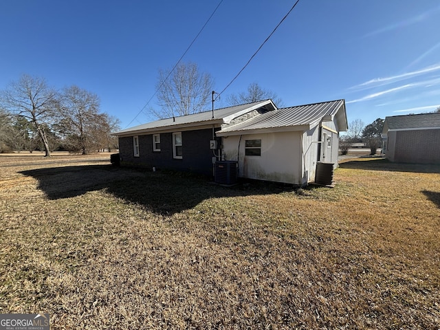 rear view of house with a lawn and central AC