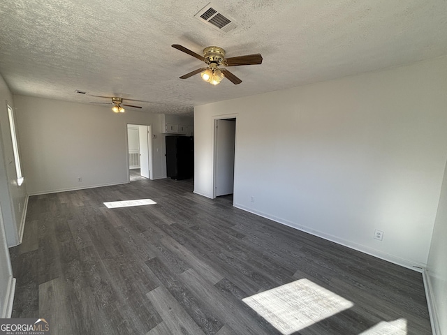 unfurnished room featuring ceiling fan, dark hardwood / wood-style floors, and a textured ceiling