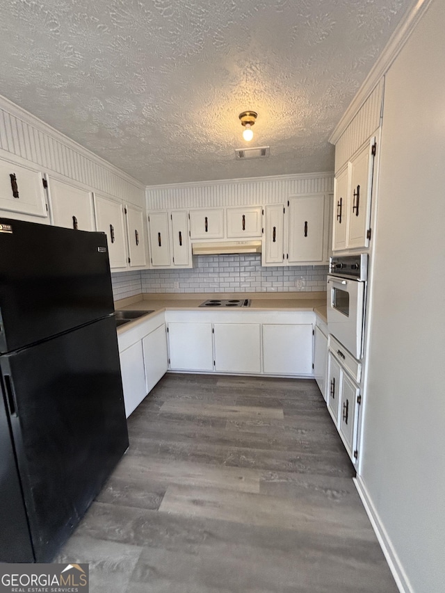 kitchen featuring dark hardwood / wood-style flooring, white cabinets, tasteful backsplash, and white appliances