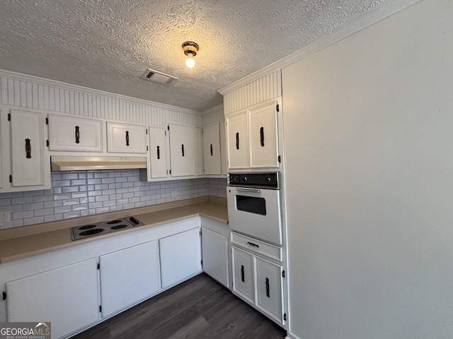 kitchen featuring ornamental molding, dark hardwood / wood-style flooring, white cabinets, and white appliances