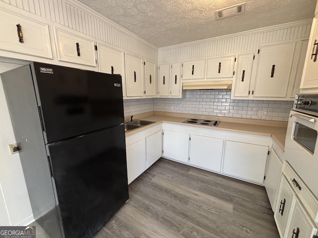 kitchen featuring white cabinets, sink, white appliances, and a textured ceiling