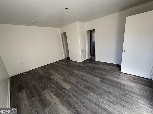 empty room with dark hardwood / wood-style flooring