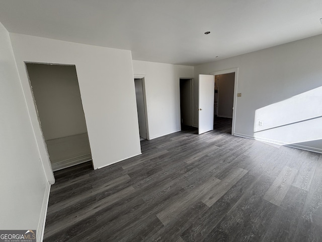 unfurnished bedroom with dark hardwood / wood-style floors and a closet