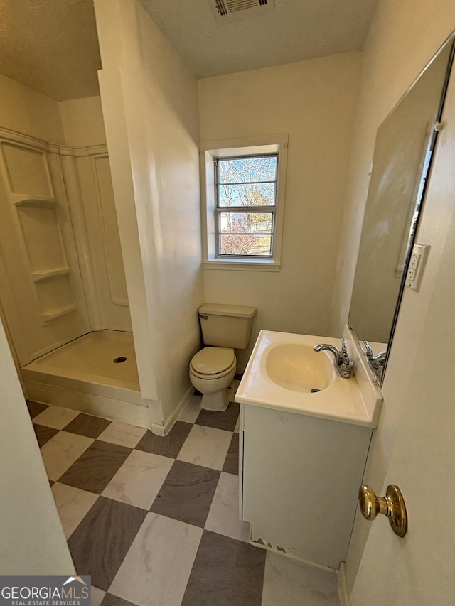 bathroom with walk in shower, vanity, and toilet