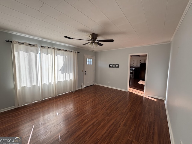 spare room with dark wood-type flooring, crown molding, and ceiling fan