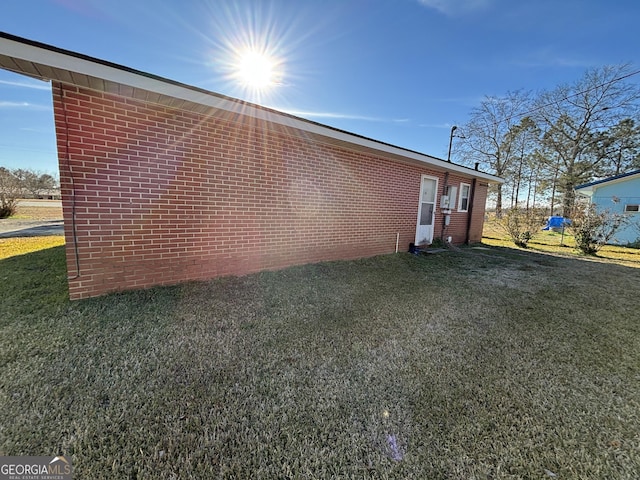 view of side of home with a yard