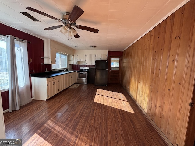 kitchen with dark hardwood / wood-style flooring, plenty of natural light, black refrigerator, and stainless steel electric range