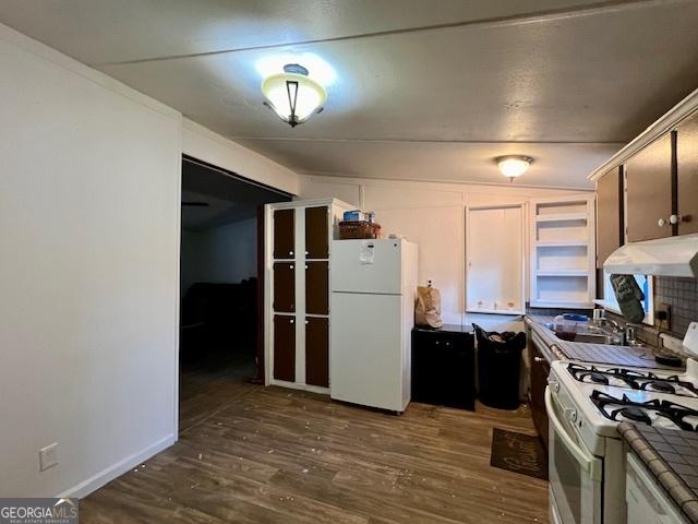 kitchen featuring dark hardwood / wood-style flooring, tile counters, and white appliances