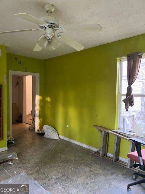 spare room with ceiling fan and a textured ceiling