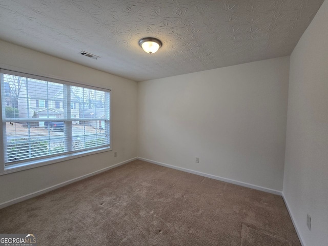 unfurnished room featuring carpet floors and a textured ceiling