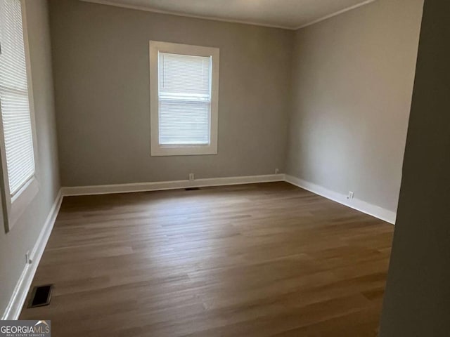 unfurnished room with dark wood-type flooring and ornamental molding