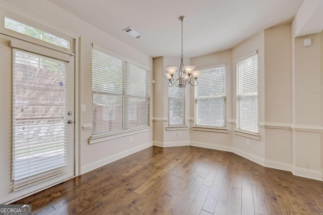 unfurnished dining area featuring dark hardwood / wood-style floors and a notable chandelier