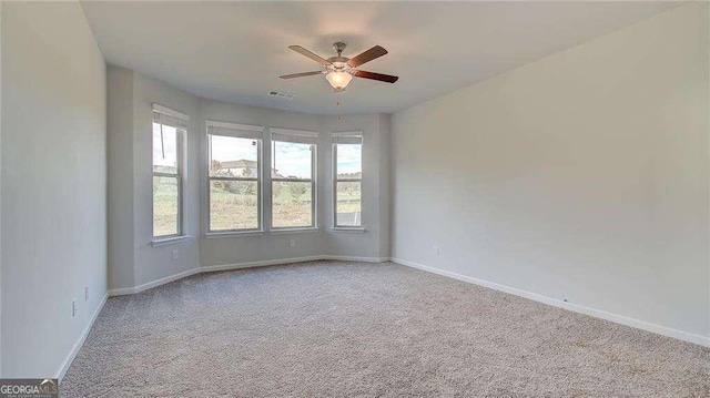 carpeted spare room featuring ceiling fan