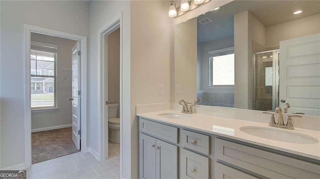 bathroom with toilet, vanity, an enclosed shower, and a wealth of natural light