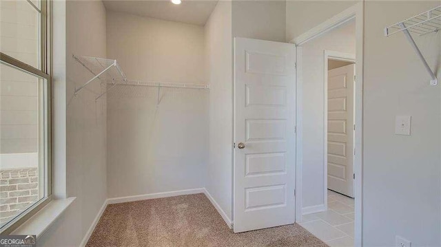 walk in closet with light colored carpet