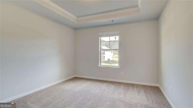 unfurnished room featuring carpet floors, a tray ceiling, and ornamental molding