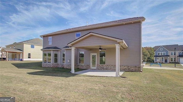 rear view of property featuring ceiling fan, a yard, and a patio