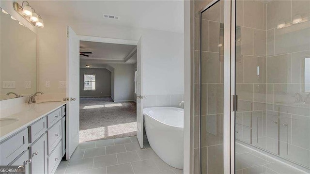 bathroom featuring ceiling fan, tile patterned floors, vanity, and plus walk in shower