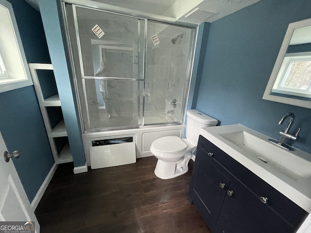 full bathroom featuring toilet, bath / shower combo with glass door, wood-type flooring, and vanity