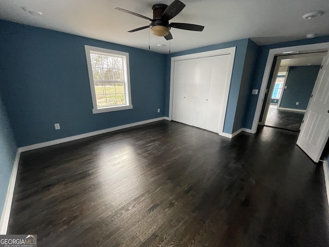 unfurnished bedroom with ceiling fan, a closet, and dark hardwood / wood-style flooring