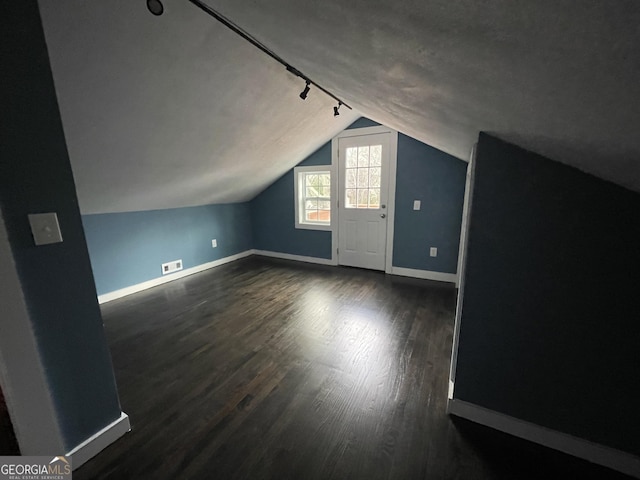 additional living space with dark wood-type flooring and lofted ceiling