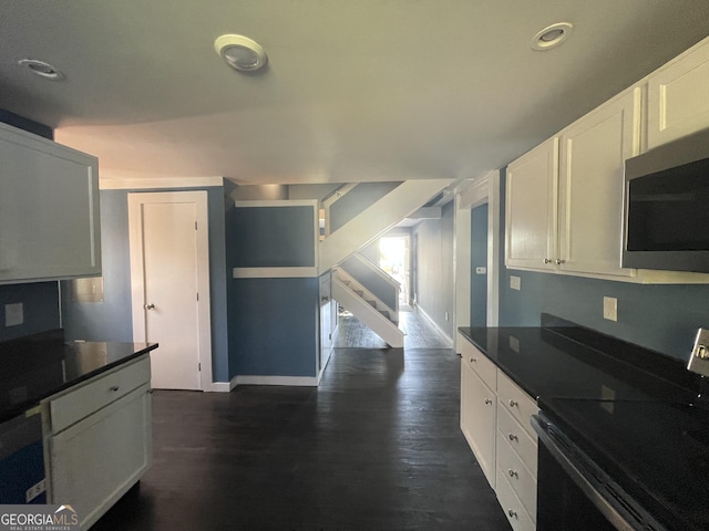 kitchen with dark wood-type flooring, electric range, and white cabinets