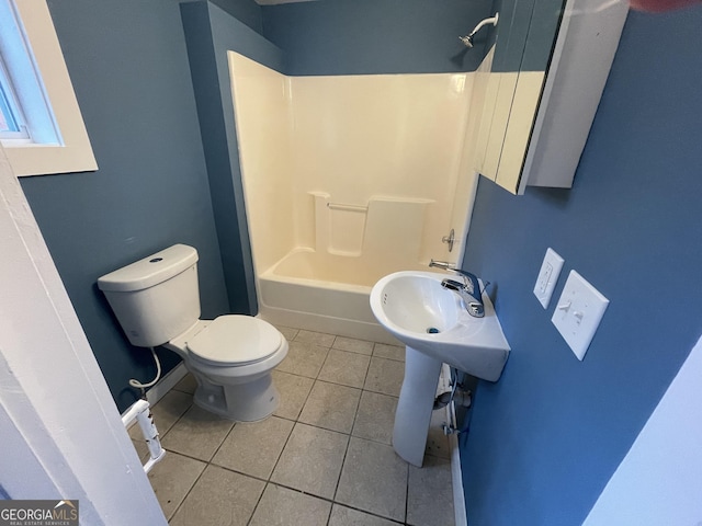 bathroom with toilet, tile patterned floors, and washtub / shower combination