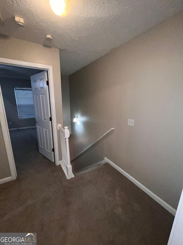 stairs featuring carpet flooring and a textured ceiling