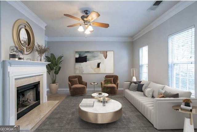 living room featuring crown molding, a high end fireplace, and ceiling fan