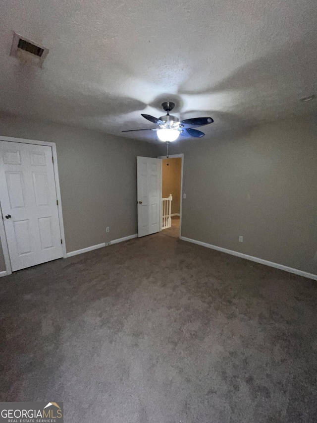 unfurnished bedroom featuring carpet floors, a textured ceiling, and ceiling fan