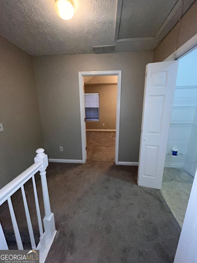 carpeted spare room with a textured ceiling