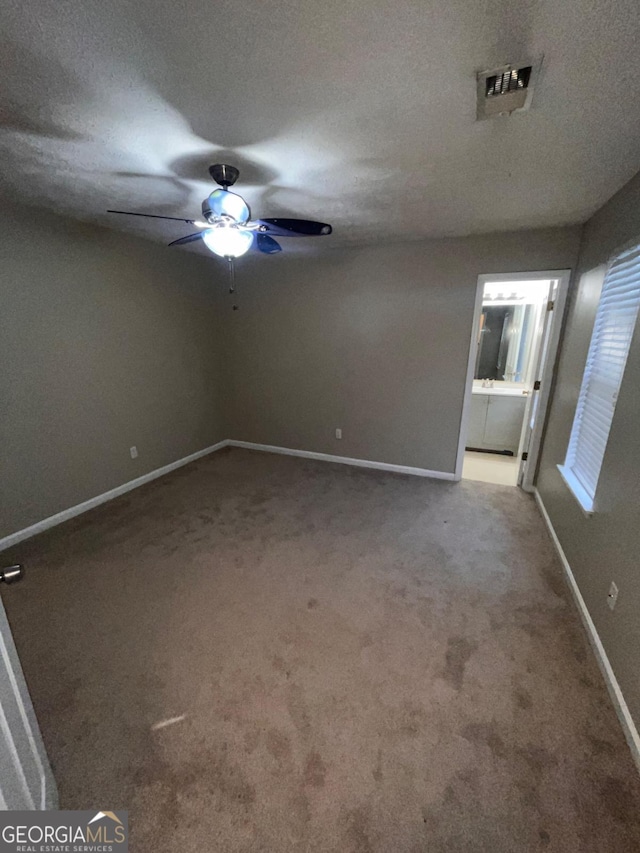 carpeted empty room with a textured ceiling and ceiling fan