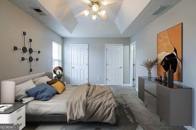 bedroom featuring ceiling fan, a raised ceiling, and dark colored carpet