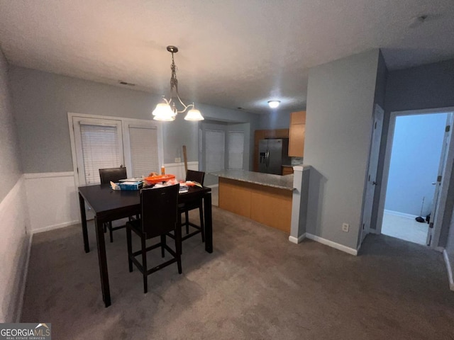 carpeted dining room with a notable chandelier