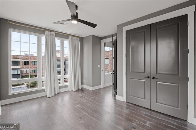 interior space with ceiling fan, a closet, and dark hardwood / wood-style floors